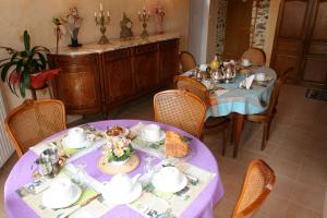 comedor con mesa y mantel púrpura en Chambres d'hôtes de Lunel, en Tresboeuf