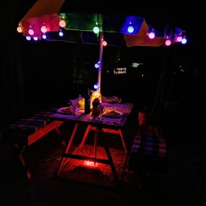 ナラタニヤにあるハギング クラウズの照明付きの暗室のテーブル