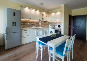a kitchen with a white table and a white refrigerator at RIVERSIDE APARTMENTS PLOVDIV with free parking in Plovdiv