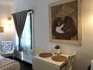 a room with a table and a painting on the wall at Chaumière au bord de l'eau - Domaine de 3 hectares - Borne Electrique - Chiens acceptés in Hondouville