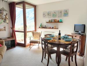 a dining room with a table and chairs and a television at Home ON SLOPES, the slope n°3 is under the balcony! in Breuil-Cervinia