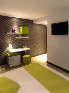 sypialnia z łóżkiem, biurkiem i telewizorem w obiekcie Rioné Hotel Boutique w mieście Cuenca