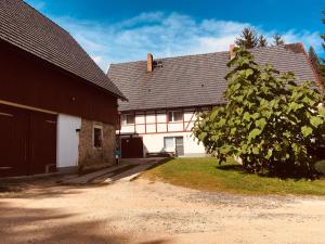 a house with a tree in front of it at Ferienwohnung „Am Gnaucks Hutberg“ in Hohnstein