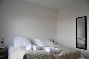 a white bedroom with a bed with towels on it at Hotel Nuka in Ilulissat
