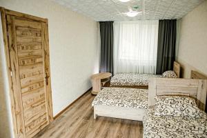 a bedroom with two beds and an open door at Everena Guest House in Rokiškis