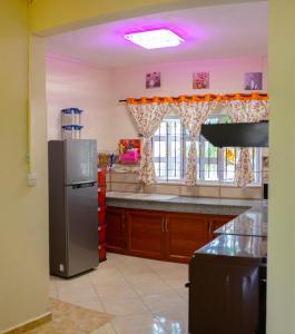 a kitchen with a stainless steel refrigerator and a window at RS VILLA private apartment with pool and free wifi in Flic-en-Flac