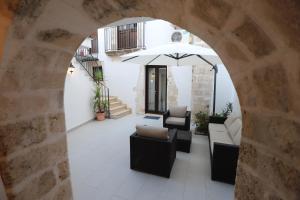 an archway with couches and an umbrella on a patio at Italiana Resort Atrio in Siracusa