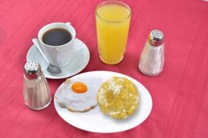 a breakfast plate with an egg and a cup of coffee at Hotel Quezada Hermanos in Santo Domingo de los Colorados