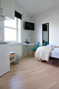 a bedroom with a bed and a table and a desk at Hotel Nuka in Ilulissat