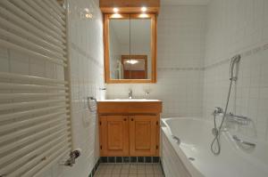a bathroom with a tub and a sink and a mirror at Grands Ducs 328 in Bagnes +30 photos
