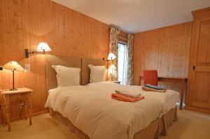 a bedroom with a large white bed with wooden walls at Grands Ducs 328 in Bagnes