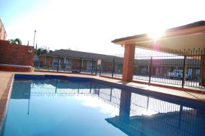a swimming pool with a fence around it at Australian Settlers Motor Inn in Swan Hill