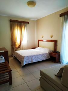 1 dormitorio con 1 cama y 1 sofá en Filoxenia Hotel, en Ioannina
