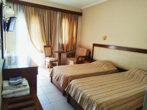 a hotel room with a bed and a chair at Filoxenia Hotel in Ioannina