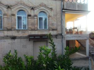 un edificio de ladrillo con balcón y escalera en Stone House, en Tskaltubo
