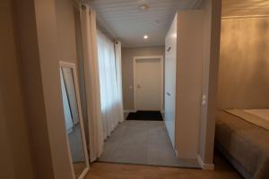 einen Flur mit einem Bett und einer Tür zu einem Zimmer in der Unterkunft Upseeritalo in Seinäjoki