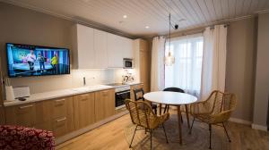 a kitchen with a table and a tv on the wall at Upseeritalo in Seinäjoki