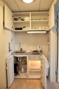 a kitchen with a sink and an open refrigerator at Hotel Nuka in Ilulissat