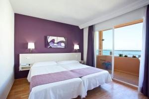 a bedroom with a white bed and a purple wall at Ona Princesa Playa in Marbella
