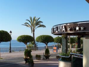 a sign for a plaza with palm trees and the ocean at Ona Princesa Playa in Marbella