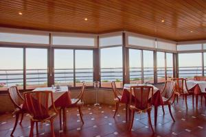 a dining room with tables and chairs and windows at Hotel Apartamentos Princesa Playa in Marbella