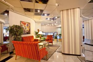 a lobby with orange chairs and a table at Ona Princesa Playa in Marbella
