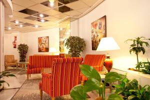 a waiting room with two red chairs and plants at Ona Princesa Playa in Marbella