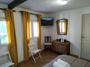 a bedroom with a bed and a dresser and a mirror at Pension Alver in Cudillero