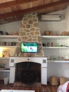 a fireplace with a tv on top of it at Can Petrel in Pollença