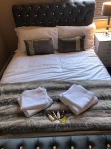 a bed with two pillows and towels on it at Southfield lodge in Middlesbrough