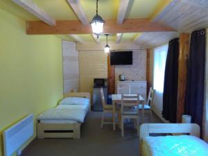 a room with two beds and a table and a dining room at Penzion U Rozcesti in Lančov