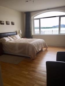 1 dormitorio con cama y ventana grande en Seaview Reenellen en Valentia Island