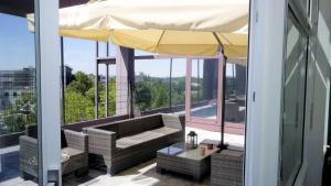 einen Balkon mit Sofa und Sonnenschirm in der Unterkunft Low Budget Hostel in München