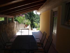 a dining table and chairs on a patio at Apartments Dumicic in Rab