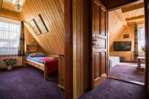 a bedroom with a bed and a tv and a door at Willa Regionalna Kosołka in Zakopane