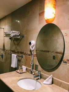 y baño con lavabo y espejo. en Hotel Casa las Mercedes, en Oaxaca City