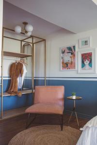 a bedroom with a chair and a blue wall at The June Motel in Picton