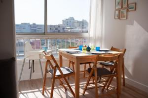 mesa y sillas en una habitación con ventana en Studio Carnon loggia au soleil et la mer à 2 pas en Mauguio