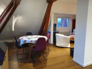 una sala da pranzo con tavolo e sedie in una stanza di Appartement Entre Monts et Lac court et moyen séjour a Nyon