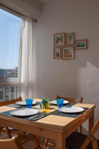 una mesa de madera con platos y cuencos en Studio Carnon loggia au soleil et la mer à 2 pas en Mauguio