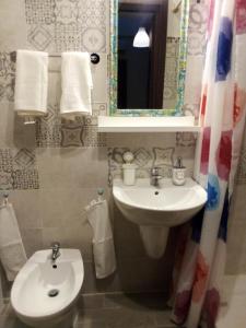 a bathroom with a sink and a toilet and a mirror at B&Bari in Bari