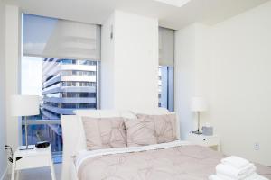 a white bedroom with a bed and a large window at Atlanta Furnished Apartments - Great location in the Heart of the City in Atlanta