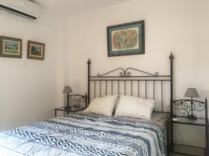 1 cama en un dormitorio con 2 mesitas de noche y 2 lámparas en Apartamento Carvajal Fuengirola en Fuengirola
