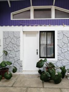 eine weiße Garagentür mit Pflanzen vor einem Gebäude in der Unterkunft Cabañas Rosy Isla Negra in Isla Negra