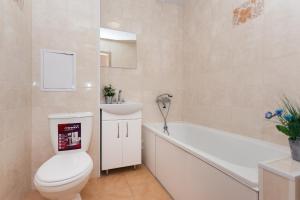 a bathroom with a toilet and a tub and a sink at Luxury apart-hotel on Kharkovskaya neer Manufaktura in Sumy +22 photos