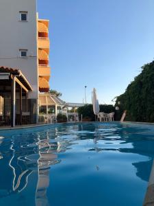 a pool at a resort with chairs and a building at Park Hotel in Alexandroupoli