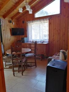 ein Esszimmer mit einem Tisch, Stühlen und einem Fenster in der Unterkunft Cabañas Rosy Isla Negra in Isla Negra