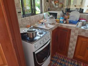 a kitchen with a stove with pots and pans on it at Morry's Apartment in Baie Sainte Anne