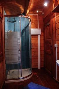Habitación de madera con baño con ducha. en Finca Pura Vida Blockhaus, en Mazo