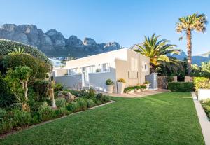 a house with a garden with mountains in the background at 3 On Camps Bay in Cape Town